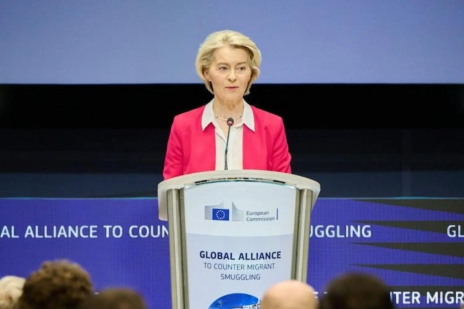 Ursula von der Leyen speaking at the podium during the second International Conference of the Global Alliance to Counter Migrant Smuggling in Brussels.